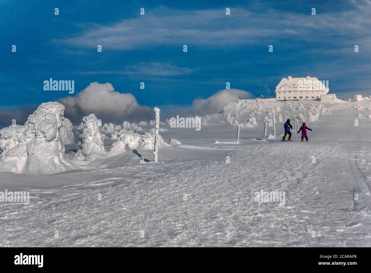 Sciare uomo e bambino in forte vento d'inverno vicino al rifugio alla cima di Szrenica, Parco Nazionale di Karkonosze, al confine tra Polonia e Repubblica Ceca Foto Stock