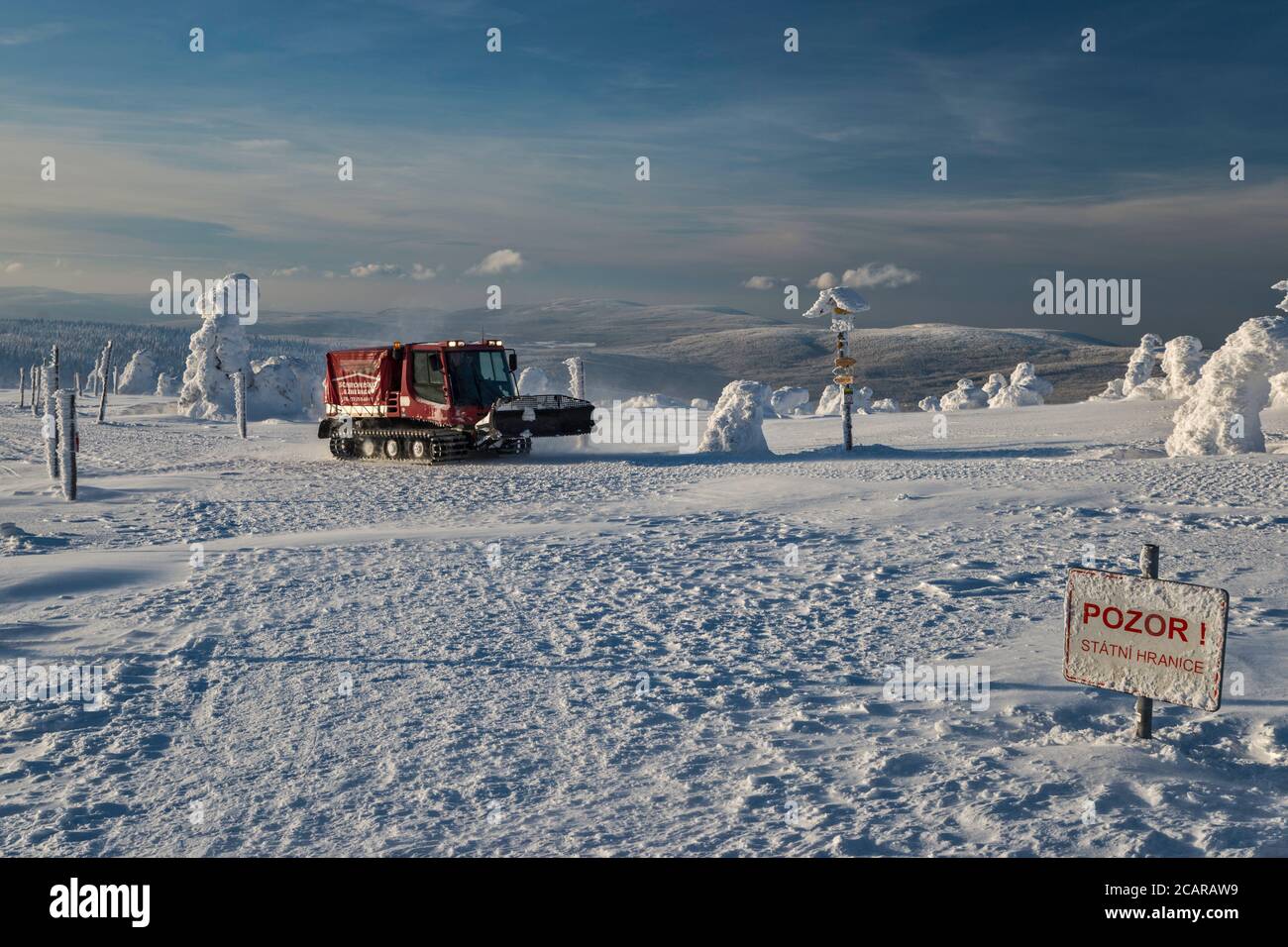 Gatto delle nevi di PistenBully, cartello di avvertimento di frontiera, sotto la cima di Szrenica, Parco Nazionale di Karkonosze al confine tra Polonia e Repubblica Ceca Foto Stock