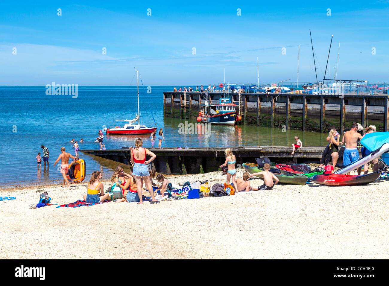 La gente prende il sole e si gode l'onda di calore alla Whitstable Beach, Kent, Regno Unito Foto Stock