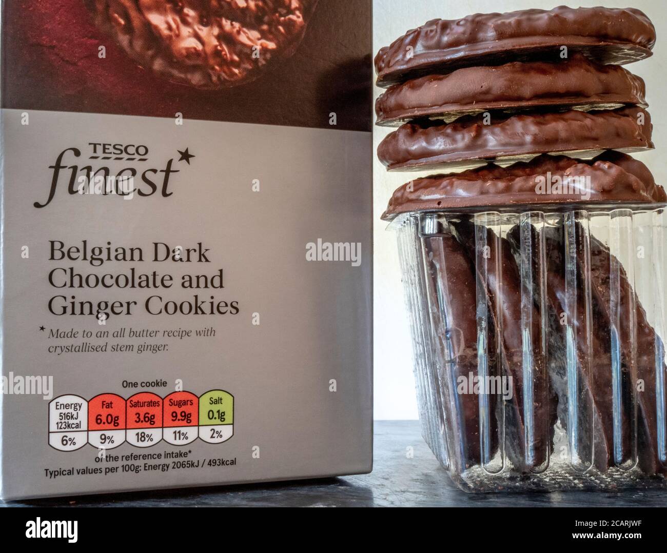 Primo piano di Tesco Finest Belgian Dark Chocolate and Ginger Cookies – scatola di prodotti al dettaglio insieme a un vassoio di biscotti della confezione. Foto Stock