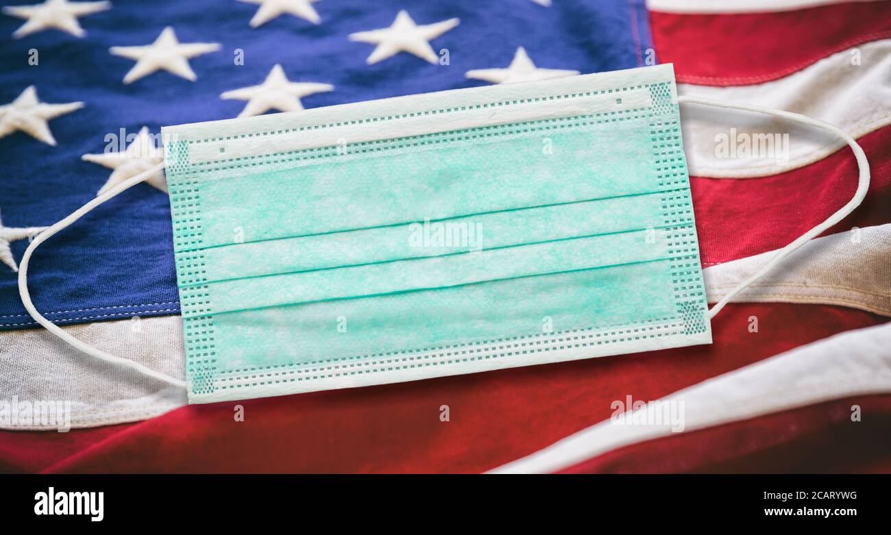 Coronavirus Covid 19 negli Stati Uniti. Maschera medica di protezione su fondo bandiera US of America. Foto Stock