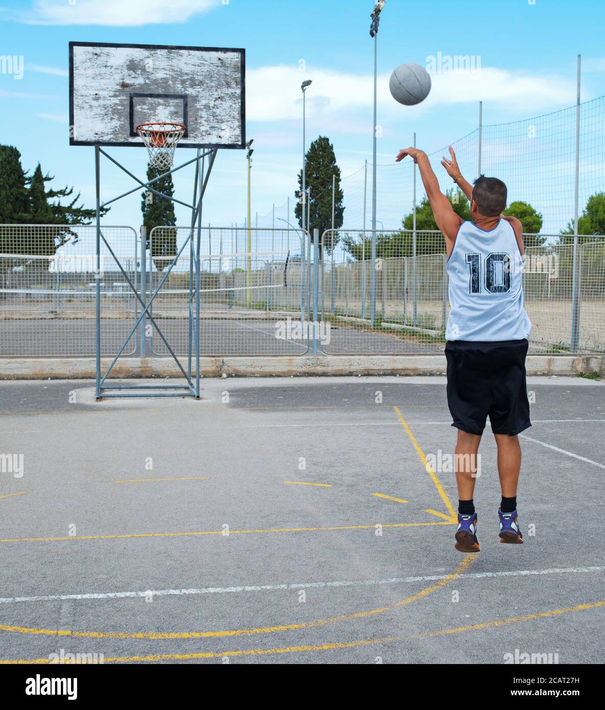 lefty giocatore di basket tiro in un parco giochi Foto Stock