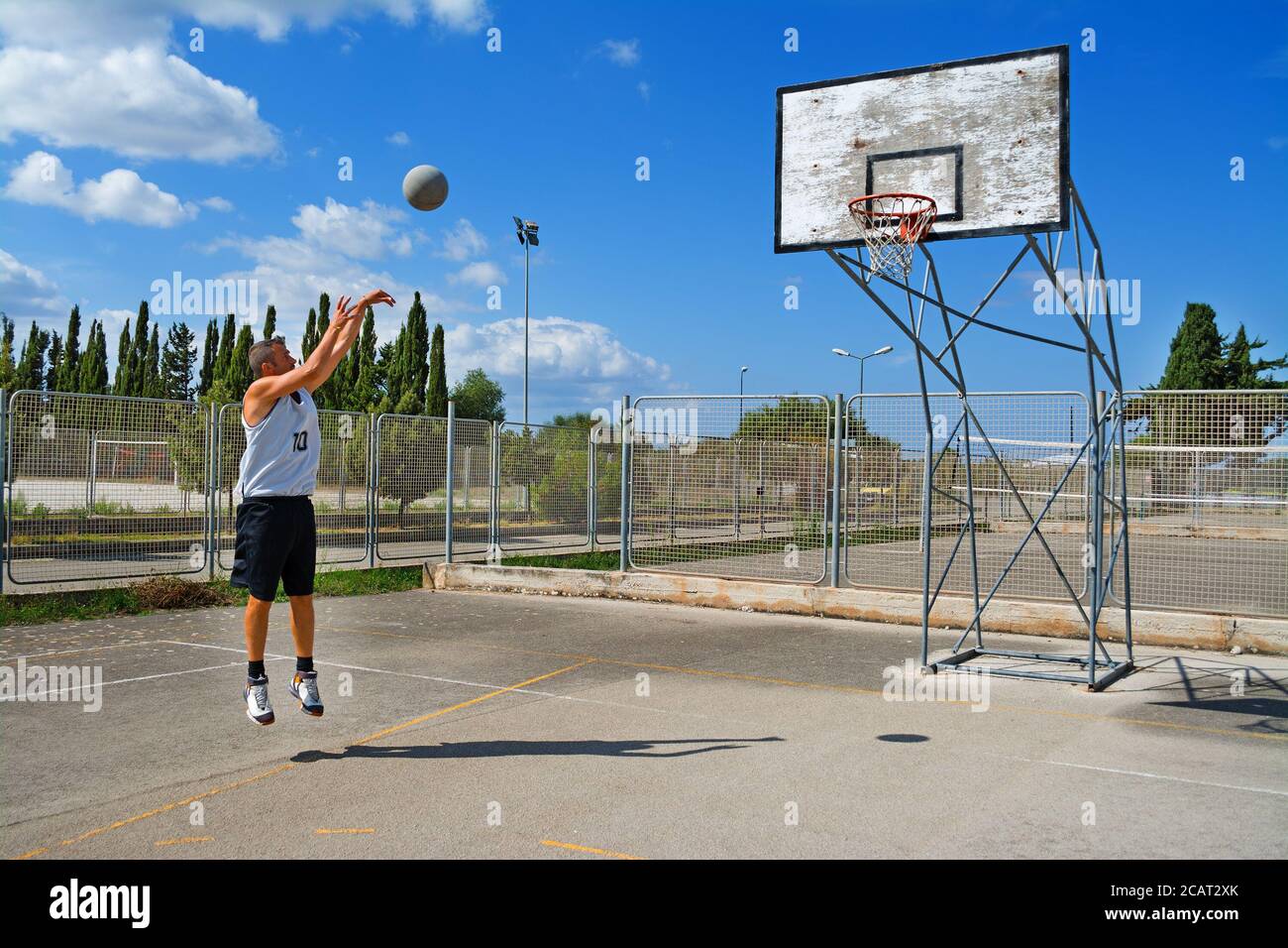 lefty giocatore di basket tiro in un parco giochi Foto Stock