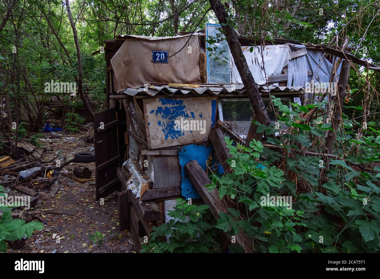 Senza tetto dimorando. Piccola abitazione fatta di spazzatura in foresta sporca disseminata Foto Stock