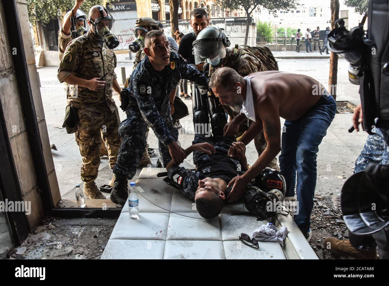 Beirut, Libano, 8 agosto 2020. Un membro leso dell’ISF viene ricucito da colleghi e attivista durante violente proteste mentre il popolo libanese è scattato per le strade a seguito di una catastrofica esplosione che ha ferito più di 6000 persone, ucciso oltre 150 persone e decimato ampie aree della capitale. Danno la colpa al loro governo a causa della negligenza irresponsabile nello stoccaggio delle 2750 tonnellate di nitrato di ammonio altamente esplosivo esploso nel porto di Beirut, in modo insicuro, in un'area popolata. Elizabeth Fitt Credit: Elizabeth Fitt/Alamy Live News Foto Stock