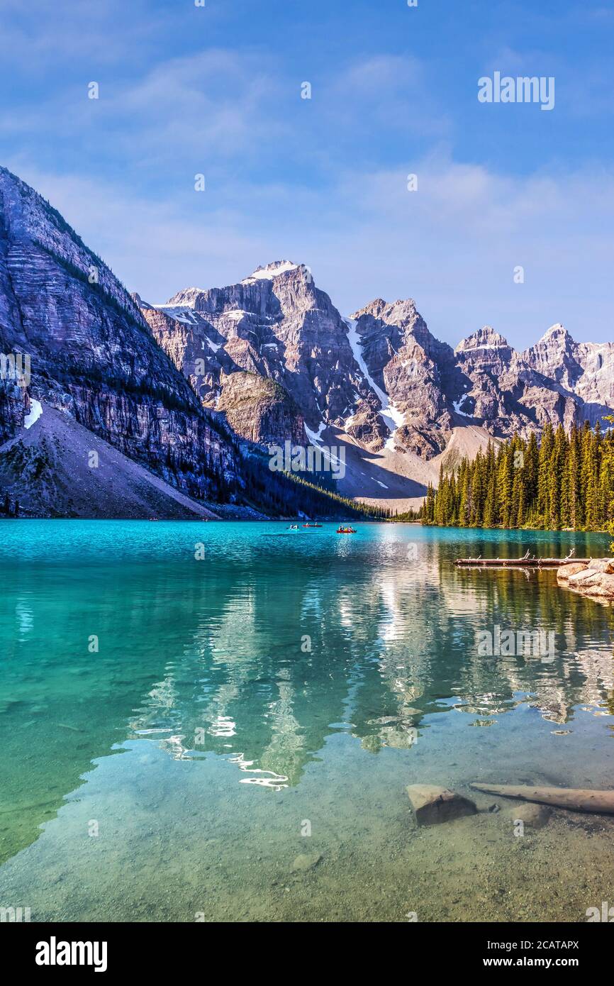 Visitatori non identificabili che possono praticare canoa sulle loro barche sul lago Moraine di colore turchese nelle Montagne Rocciose canadesi del Banff National Park vicino al lago Louise. La va Foto Stock