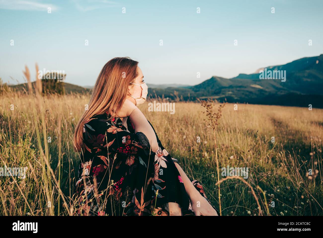 Giovane bella donna con maschera lontano dalla città in natura con splendida vista Foto Stock