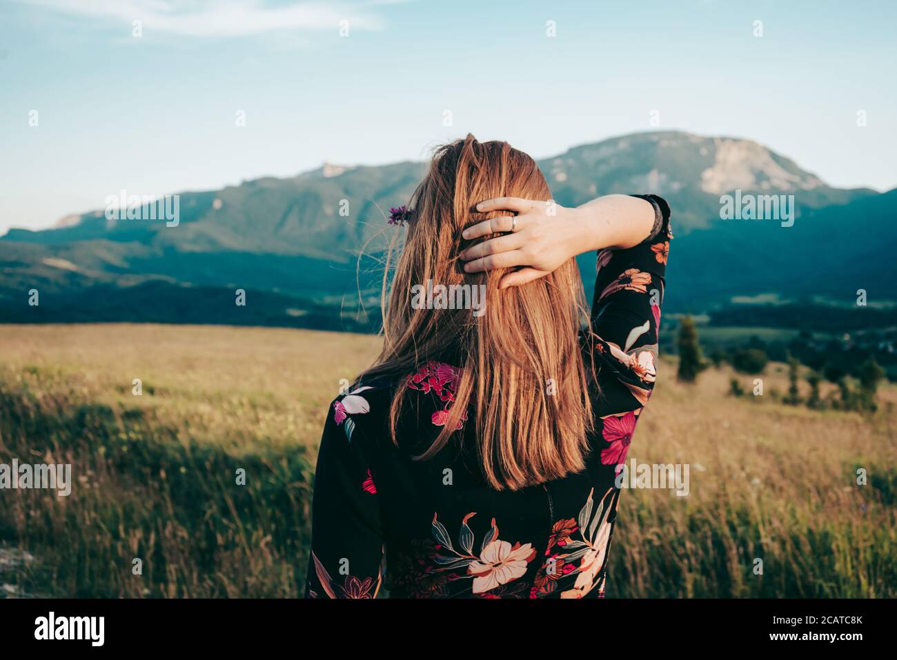 Donna bionda che gode la vista della montagna e l'aria fresca Foto Stock