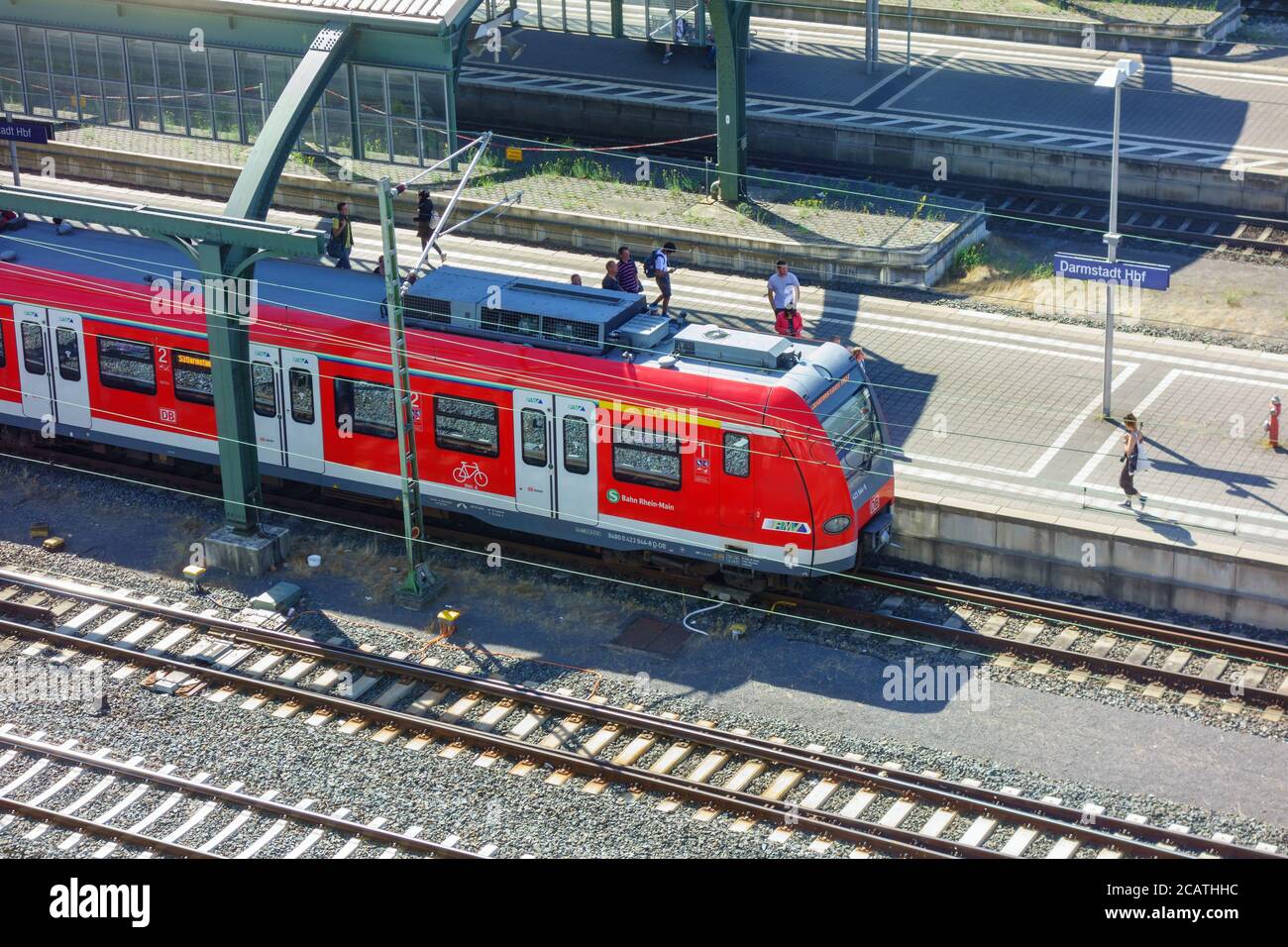 Treno per pendolari in una stazione e con pendolari Foto Stock