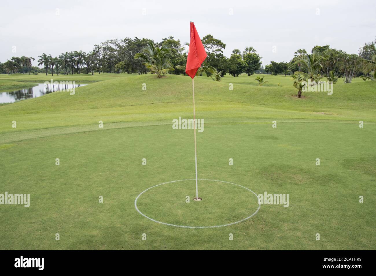 Bandiera rossa sull'erba nel campo da golf del verde Foto Stock