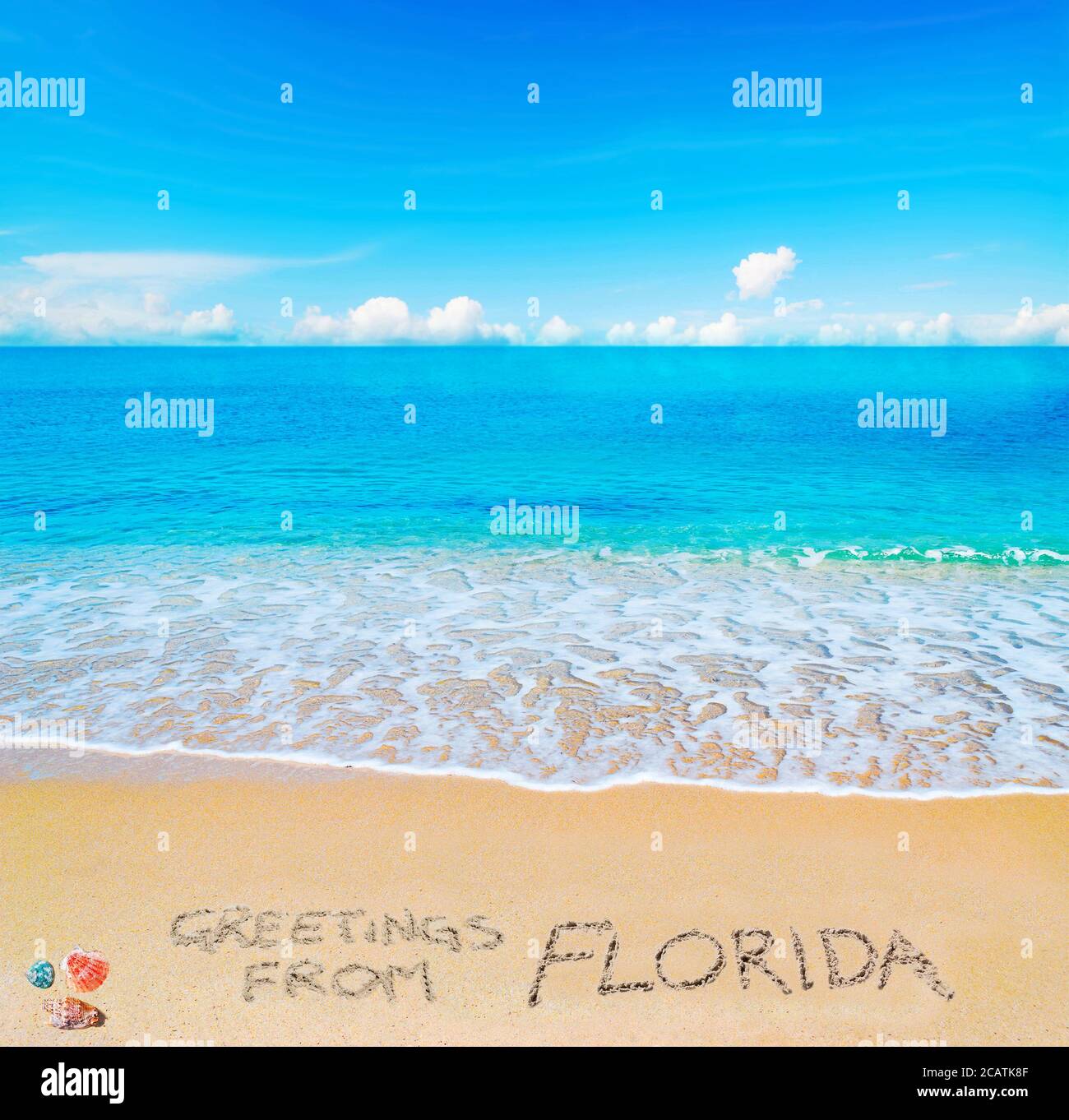 Saluti dalla Florida scritto su una spiaggia tropicale sotto le nuvole Foto Stock
