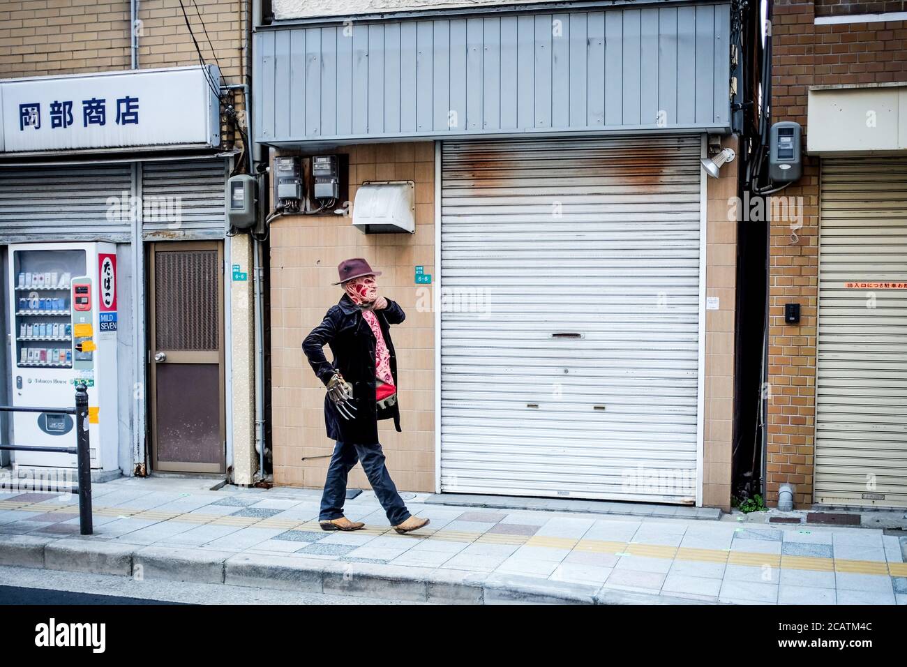 'Freddy Krueger' cammina a casa alla fine di un festival cosplay a Osaka, Giappone. Foto Stock