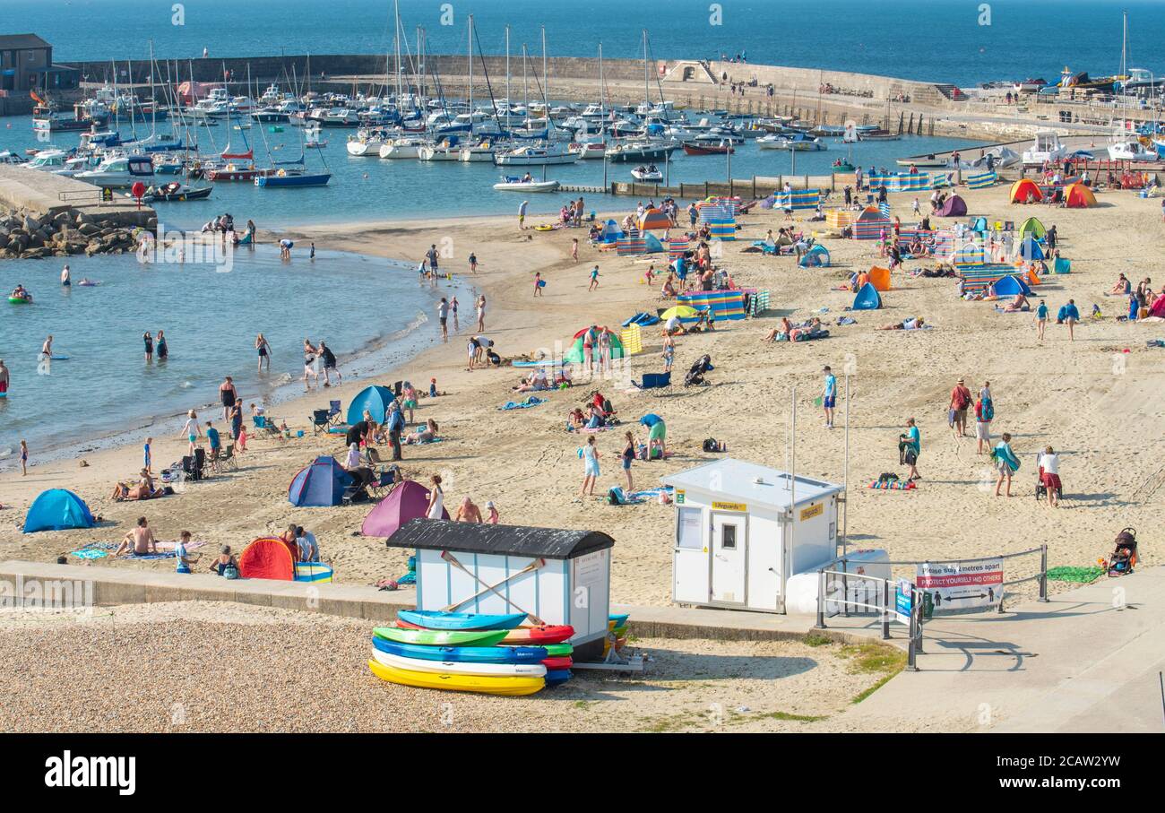 Lyme Regis, Dorset, Regno Unito. 9 agosto 2020. UK Weather: I vacanzieri e gli amanti del sole hanno colpito nuovamente la spiaggia per crogiolarsi al caldo sole della domenica mentre l'onda di calore estiva continua. I beachgoer si stanno recando in località costiere della costa meridionale per godersi il sole caldo da record e le temperature calde sfrigolanti. Credit: Celia McMahon/Alamy Live News Foto Stock