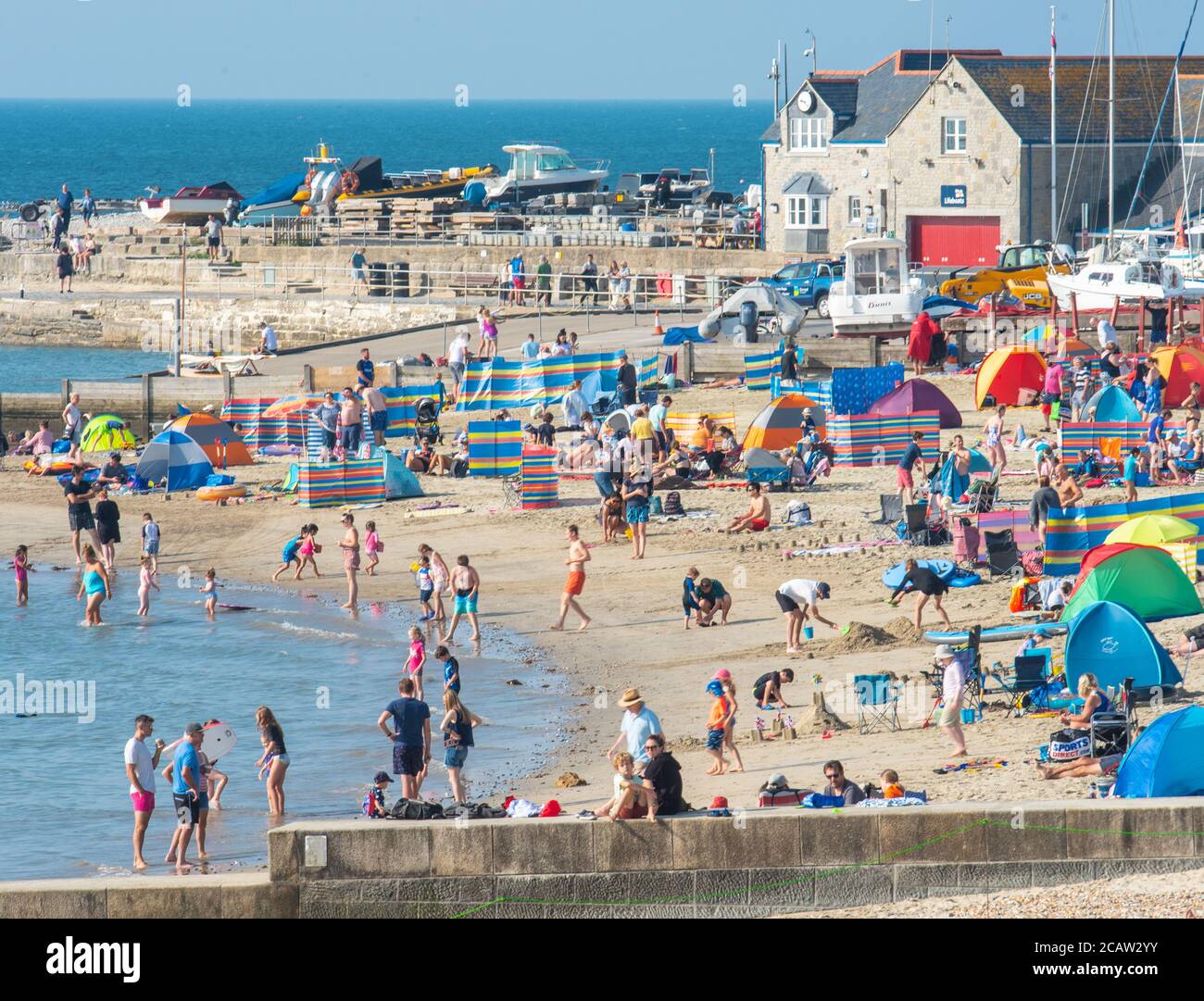 Lyme Regis, Dorset, Regno Unito. 9 agosto 2020. UK Weather: I vacanzieri e gli amanti del sole hanno colpito nuovamente la spiaggia per crogiolarsi al caldo sole della domenica mentre l'onda di calore estiva continua. I beachgoer si stanno recando in località costiere della costa meridionale per godersi il sole caldo da record e le temperature calde sfrigolanti. Credit: Celia McMahon/Alamy Live News Foto Stock