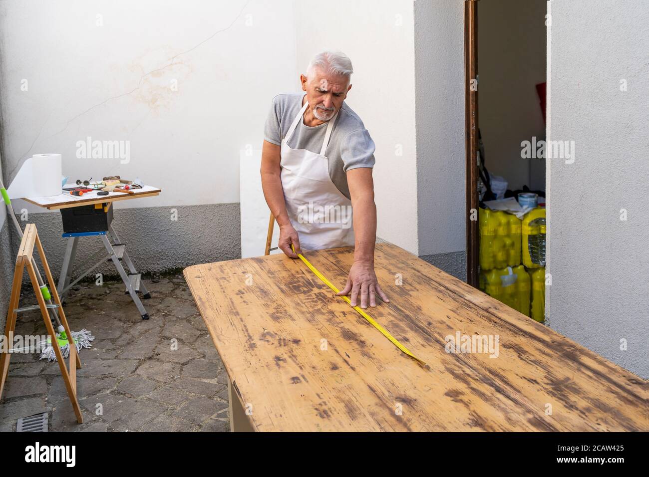 carpentiere professionista sta costruendo un tavolo di legno all'aperto officina Foto Stock
