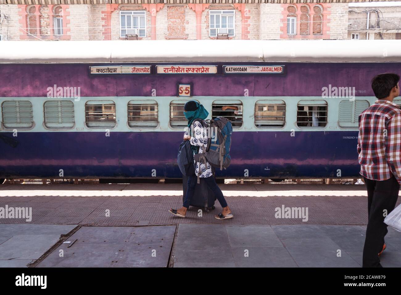Pushkar / India - 10 marzo 2020: Donne che coprono il viso con sciarpa durante la pandemia di coronavirus nella piattaforma della stazione ferroviaria Foto Stock