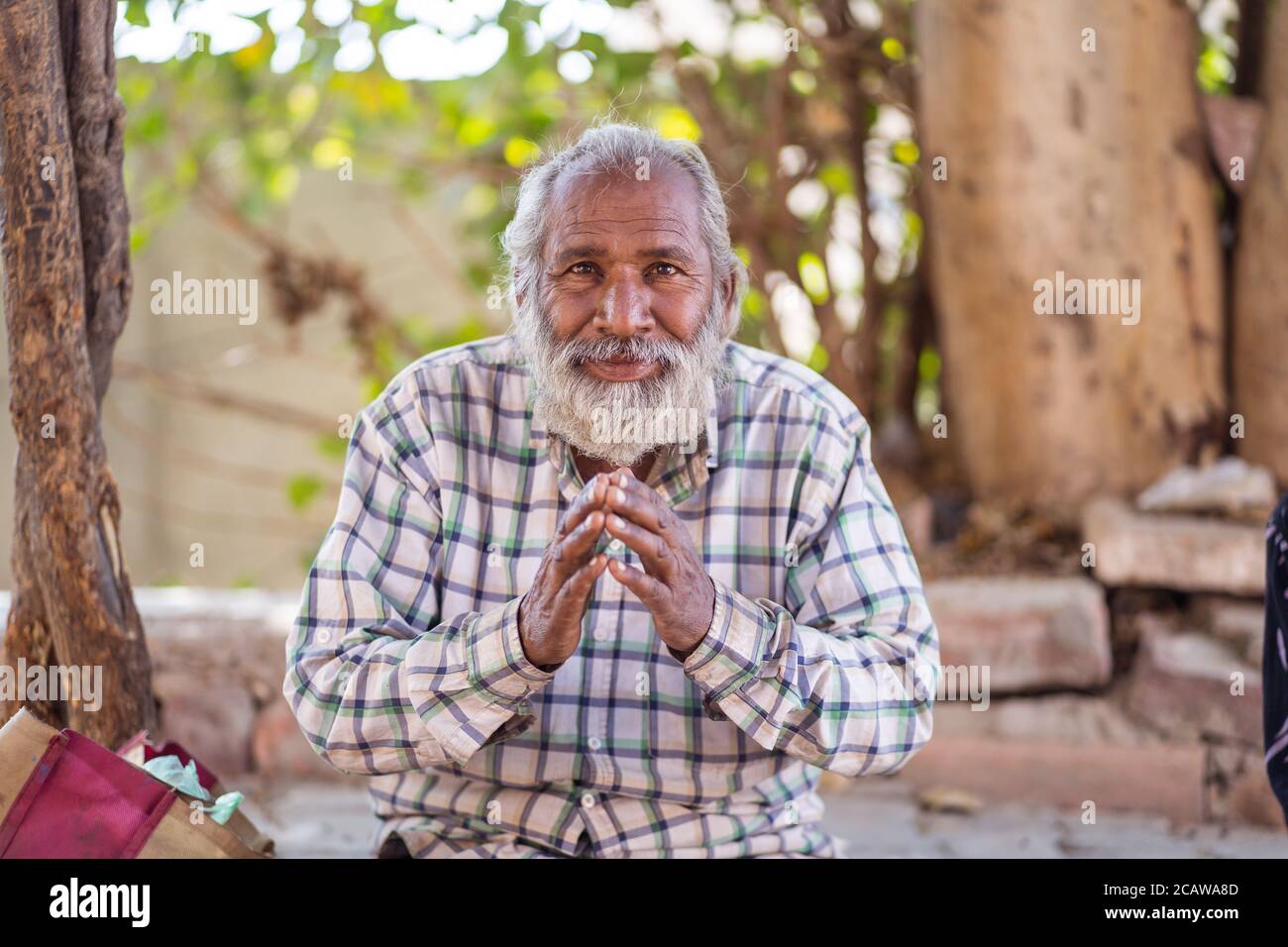 Jodhpur / India - 18 marzo 2020: Ritratto di Rajasthani indiano uomo con i capelli bianchi aggrappando le sue mani come saluto Foto Stock