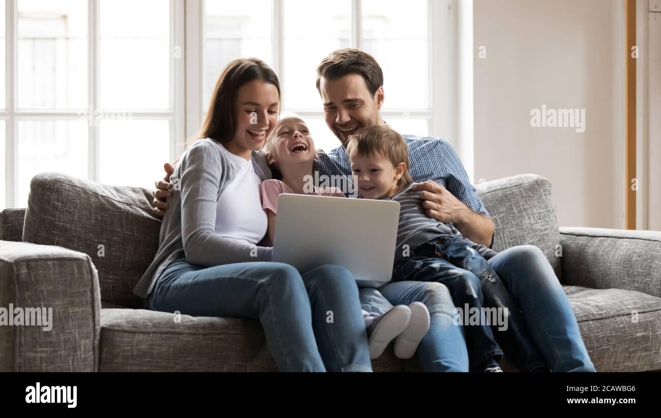 Buon legame famiglia godendo guardare divertente film comico sul portatile. Foto Stock