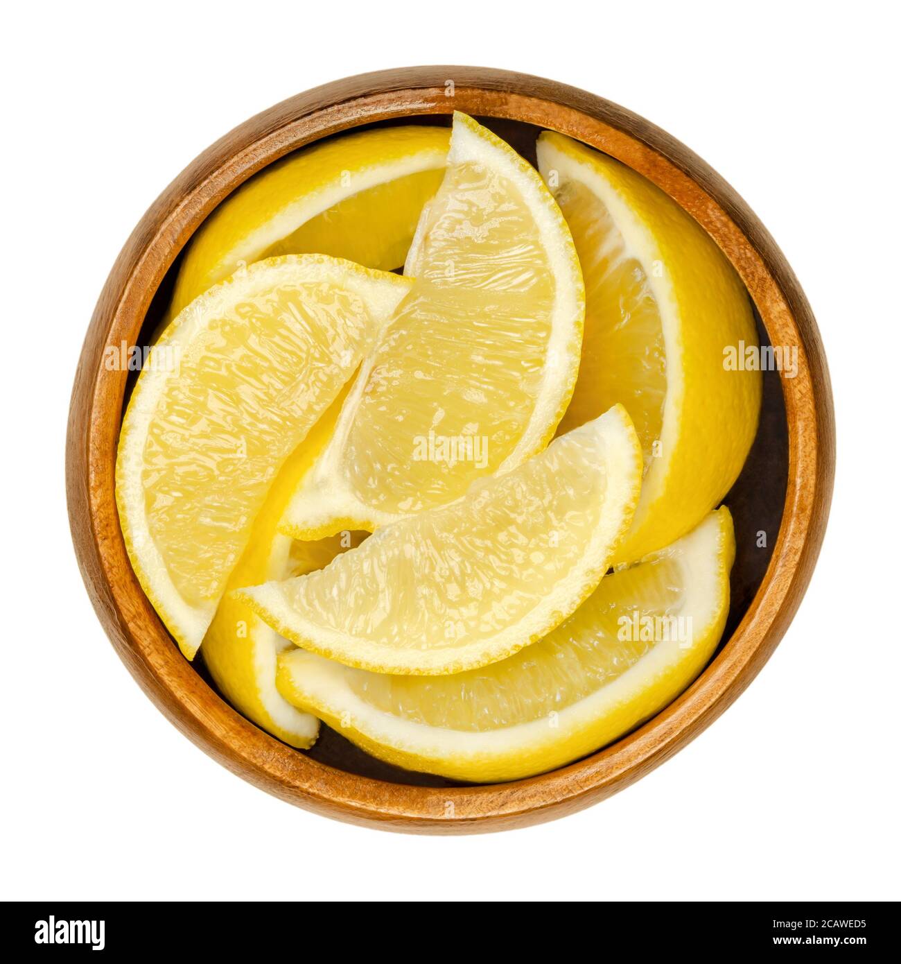 Mezzo limone in ciotola di legno. Agrumi giallo commestibile appena tagliati. Limone di agrumi. Il succo di limone viene utilizzato per scopi culinari e per la pulizia. Foto Stock