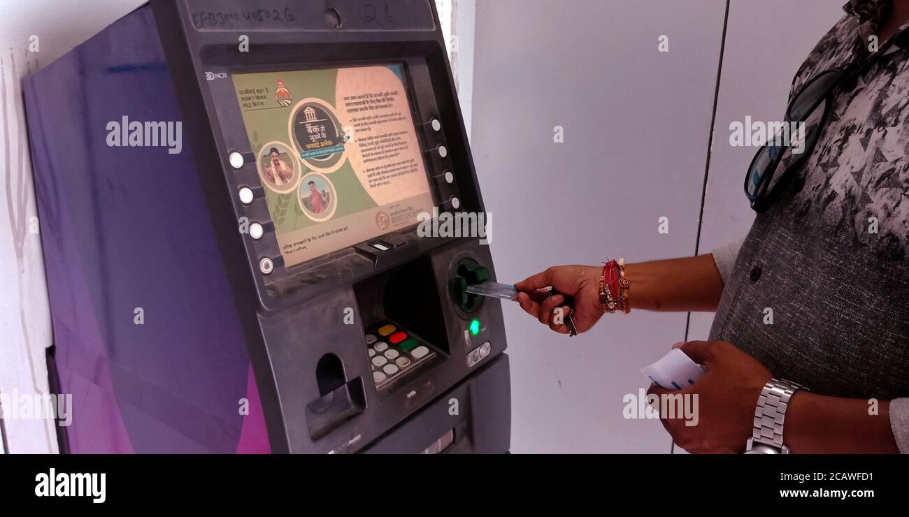 Distretto Katni, Madhya Pradesh, India - 25 agosto 2019: Carta di debito che entra dall'uomo nella macchina ATM per il prelievo di contanti presso la banca di stato dell'india. Foto Stock