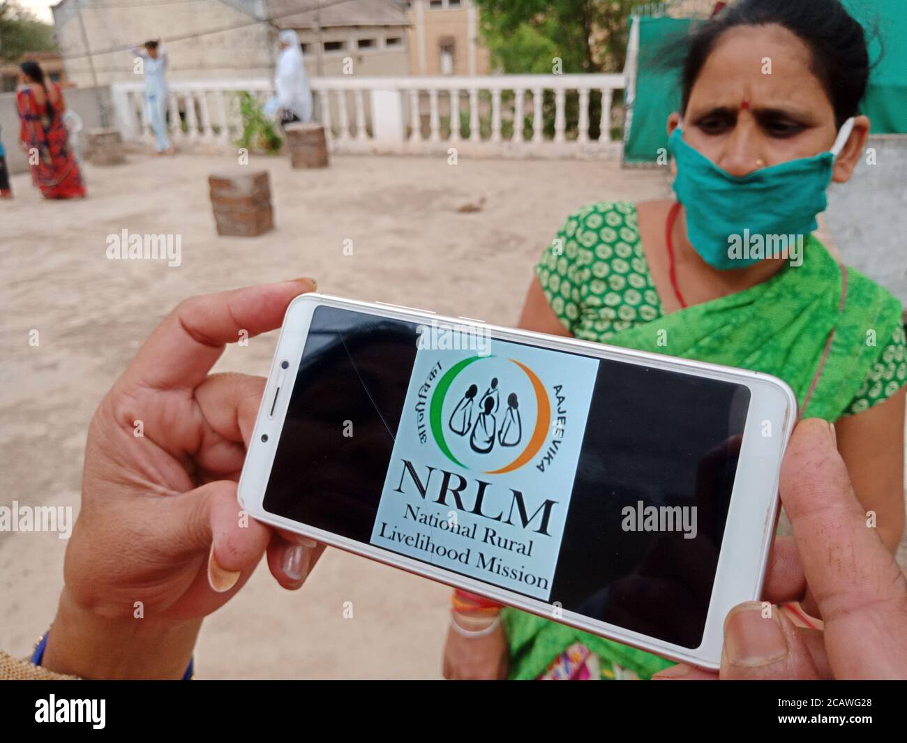 Distretto Katni, Madhya Pradesh, India - 23 maggio 2020: NRLM programma nazionale di governo della missione di sostentamento rurale visualizzato a mano sullo schermo dello smartphone Foto Stock