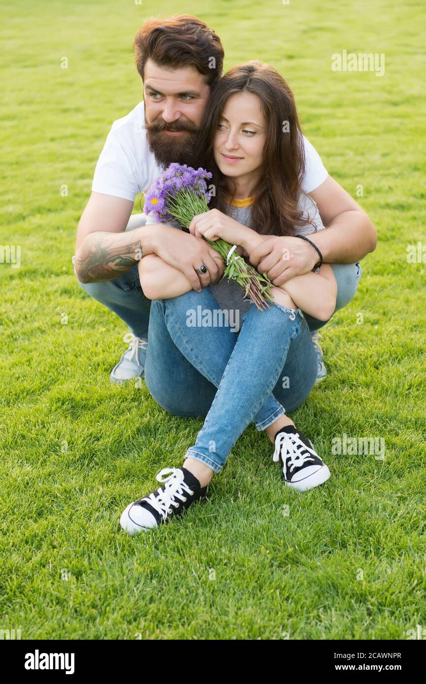 Bella coppia coccolarsi rilassandosi sul prato verde, sempre insieme concetto. Foto Stock