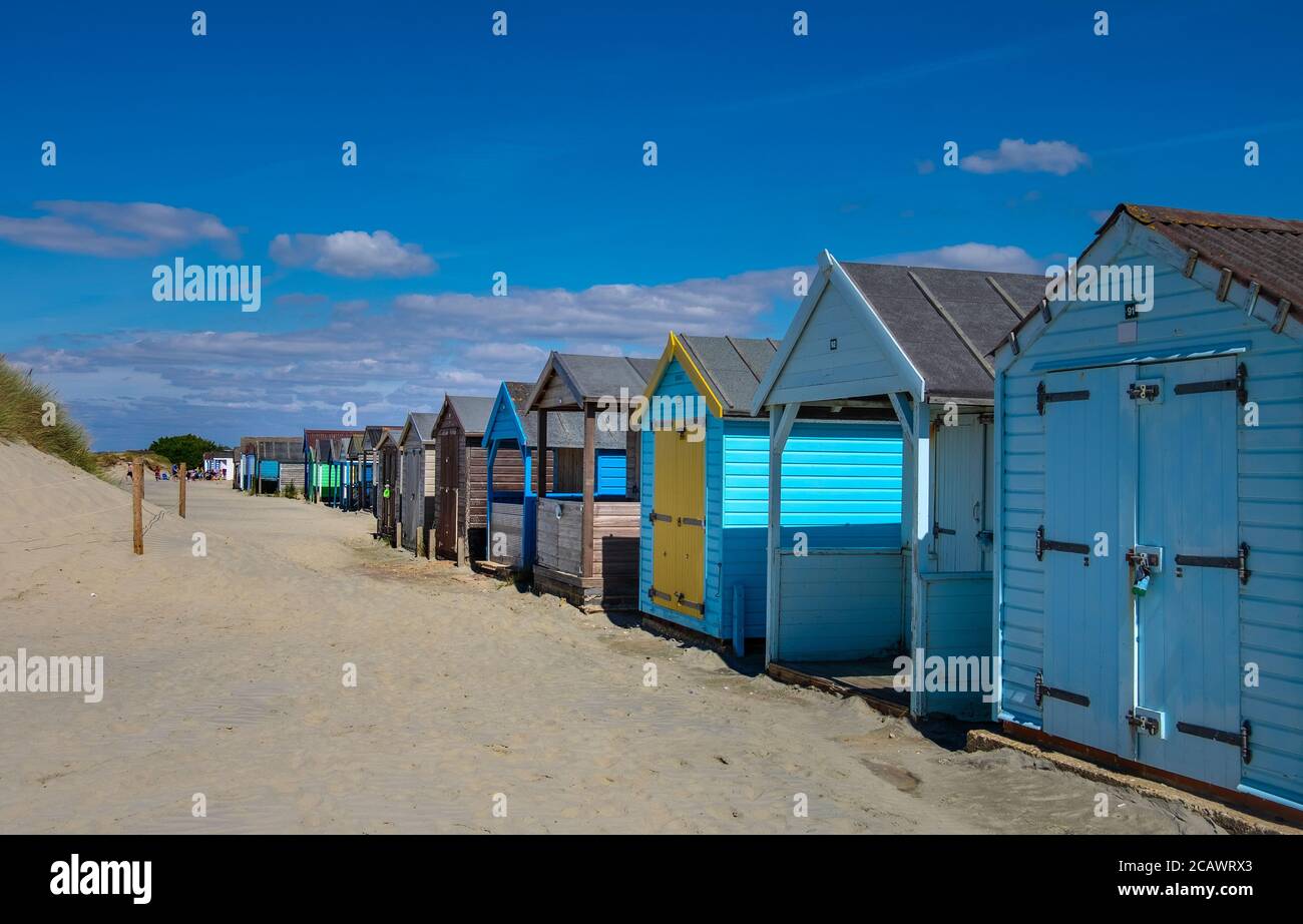 Fila di colorate capanne sulla spiaggia di sabbia in piena luce del sole. Foto Stock