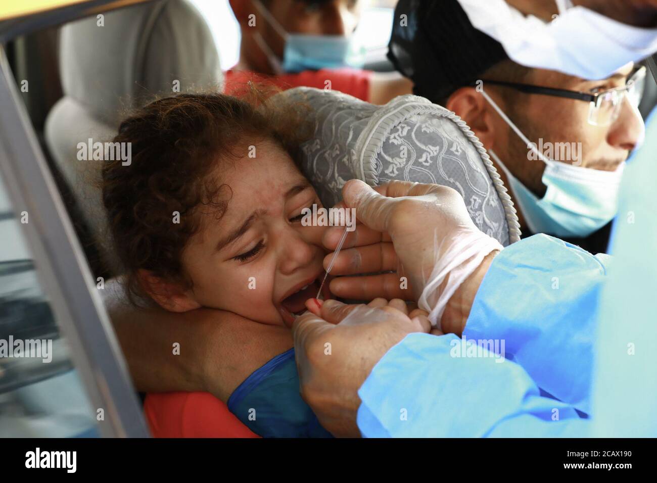 Najaf, Iraq. 09 agosto 2020. Un medico iracheno raccoglie gocce di sangue da una ragazza su un kit di analisi per la raccolta del sangue presso una stazione di test drive-through del coronavirus (COVID-19). Credit: Ameer al Mohammedaw/dpa/Alamy Live News Foto Stock