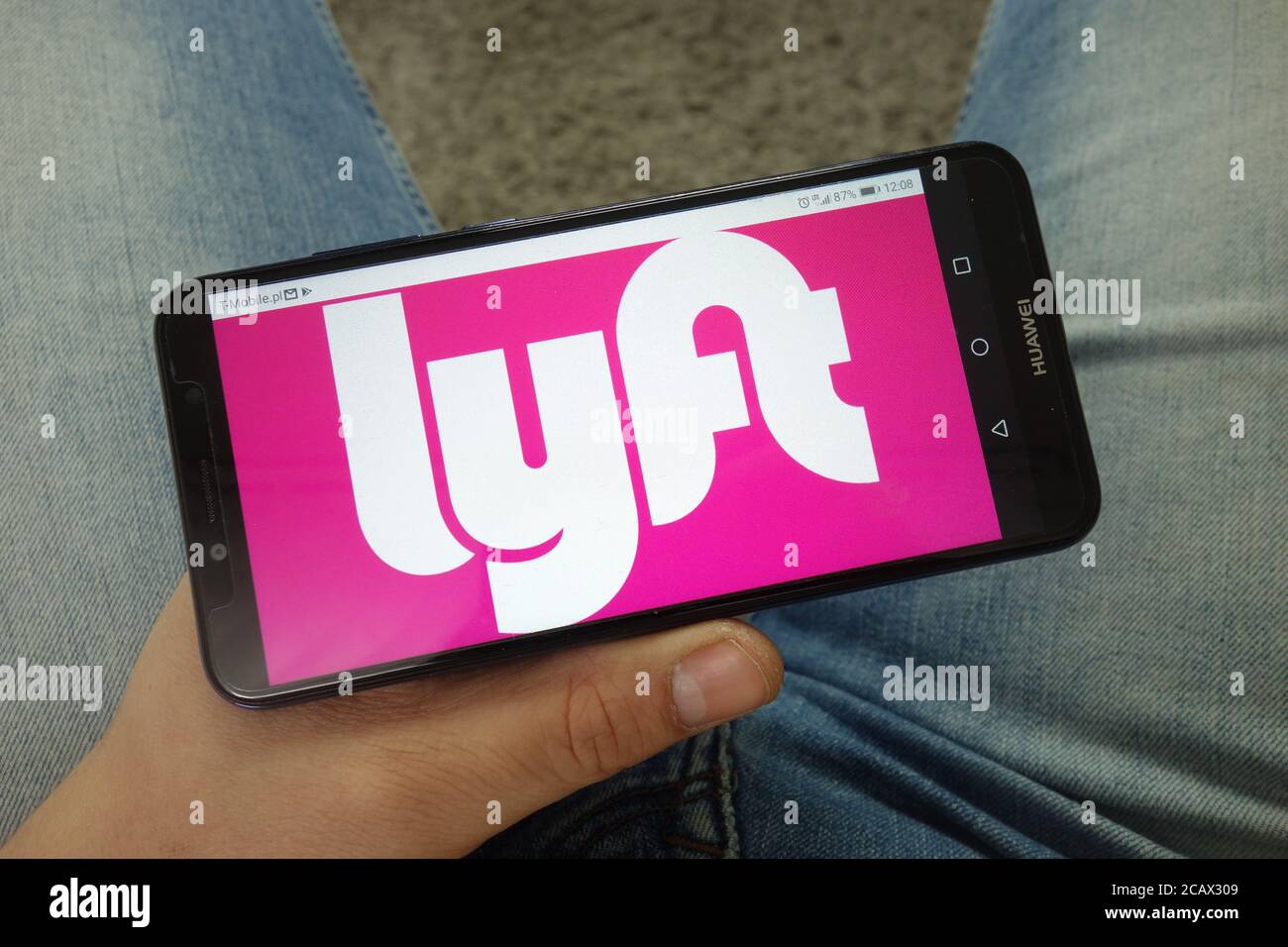 Uomo che tiene uno smartphone con il logo della società di rete di trasporto Lyft Foto Stock