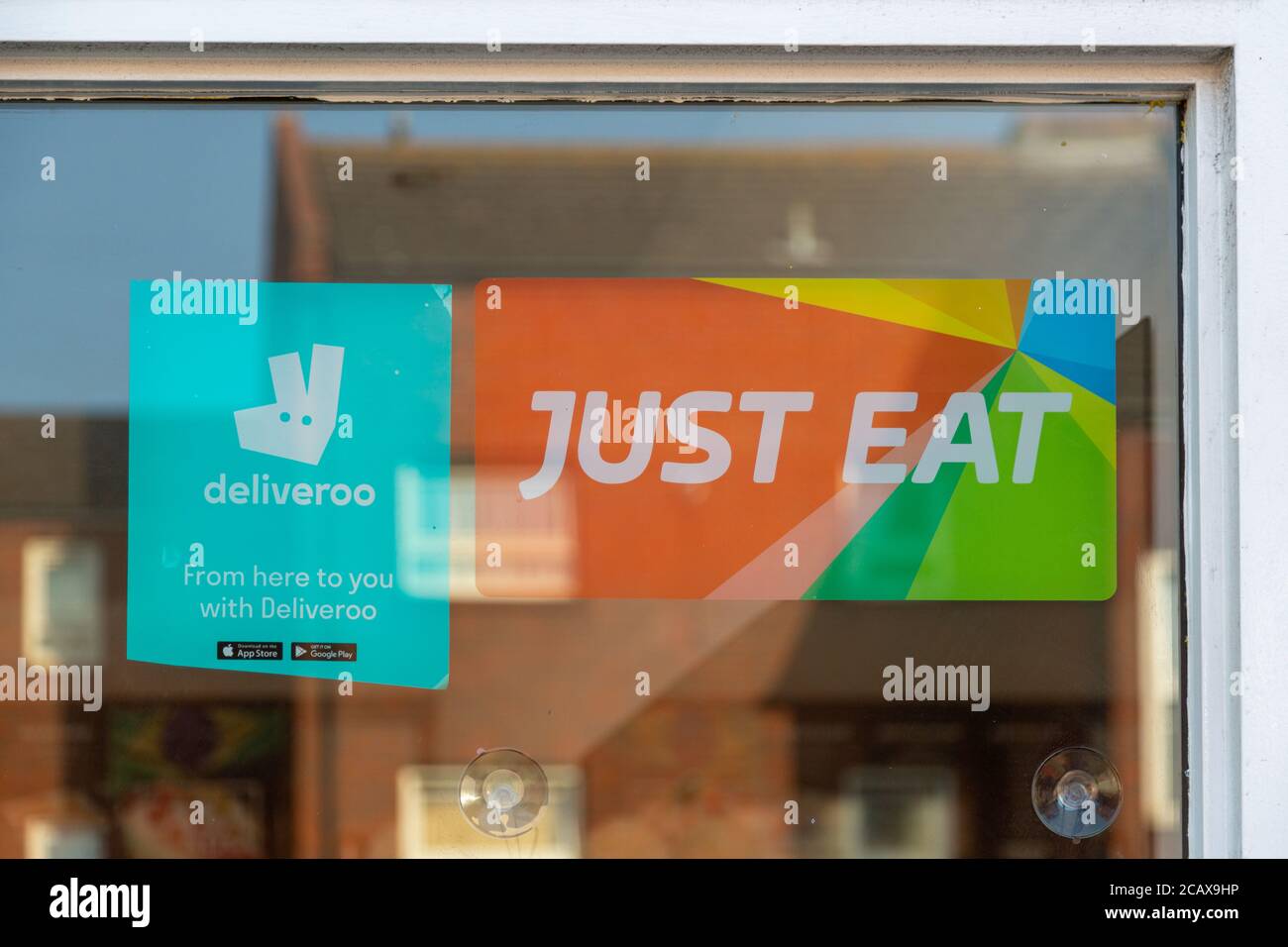 Un deliveroo e solo mangiare segno nella finestra di un ristorante o da asporto Foto Stock