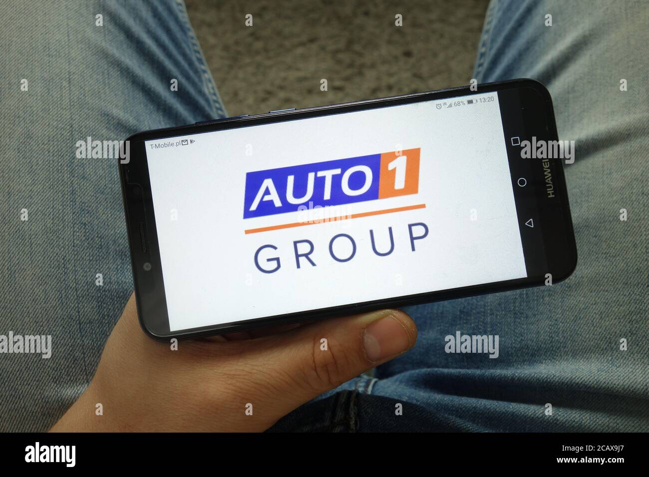 Smartphone uomo con logo Auto1 Group per la piattaforma di trading auto Foto Stock