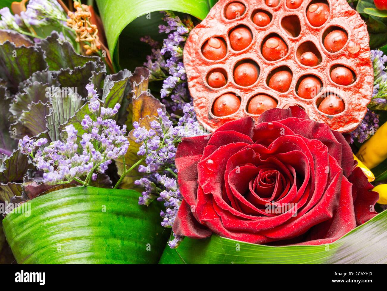 Bouquet di rose e fiori strani. Bel bouquet di rose rosse di velluto e piante diverse. Splendido lavoro fiorista Foto Stock