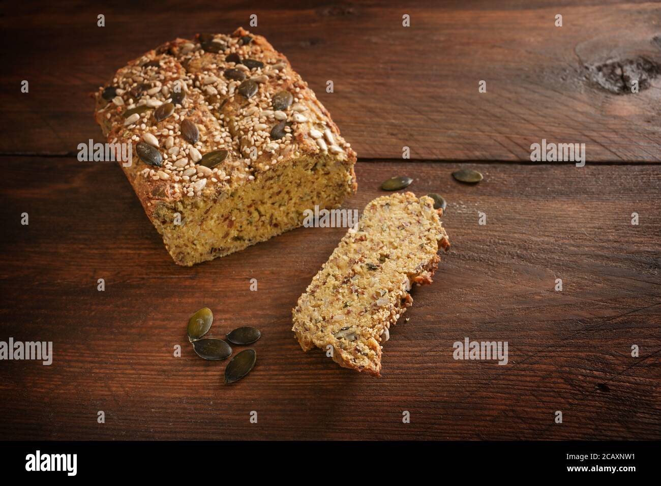 Pane proteico sano da farina di lupino, crusca di avena, mandorla, semi di zucca e altri ingredienti sani su un tavolo di legno rustico scuro per carb basso o k Foto Stock