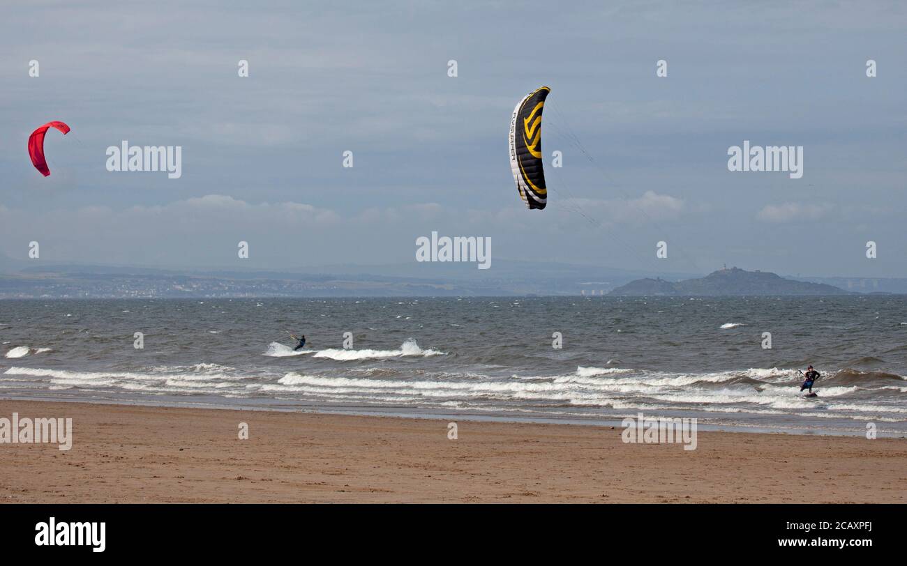 Portobello, Edimburgo, Scozia, Regno Unito. 9 agosto 2020. Kite surfers che cattura il vento. Più persone sulla spiaggia nel tardo pomeriggio, il vento fresco che dà la rara opportunità di Kite Surf sul Firth of Forth a Porty. Foto Stock