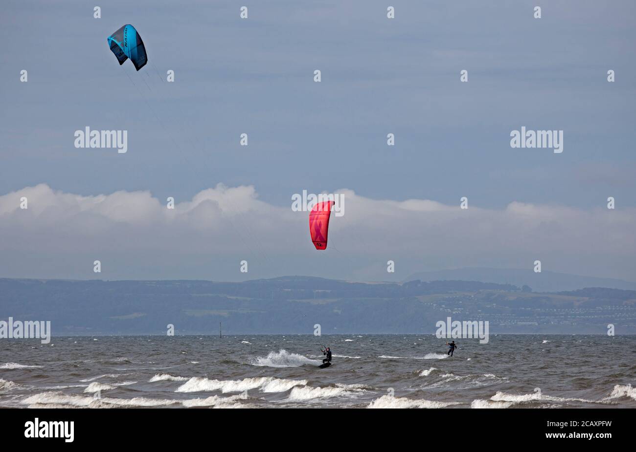 Portobello, Edimburgo, Scozia, Regno Unito. 9 agosto 2020. Kite surfers che cattura il vento. Più persone sulla spiaggia nel tardo pomeriggio, il vento fresco che dà la rara opportunità di Kite Surf sul Firth of Forth a Porty. Foto Stock
