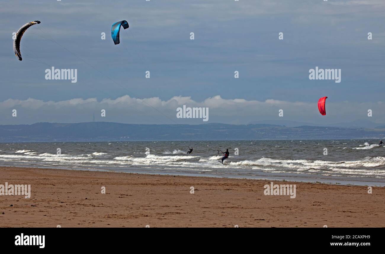Portobello, Edimburgo, Scozia, Regno Unito. 9 agosto 2020. Kite surfers che cattura il vento. Più persone sulla spiaggia nel tardo pomeriggio, il vento fresco che dà la rara opportunità di Kite Surf sul Firth of Forth a Porty. Foto Stock