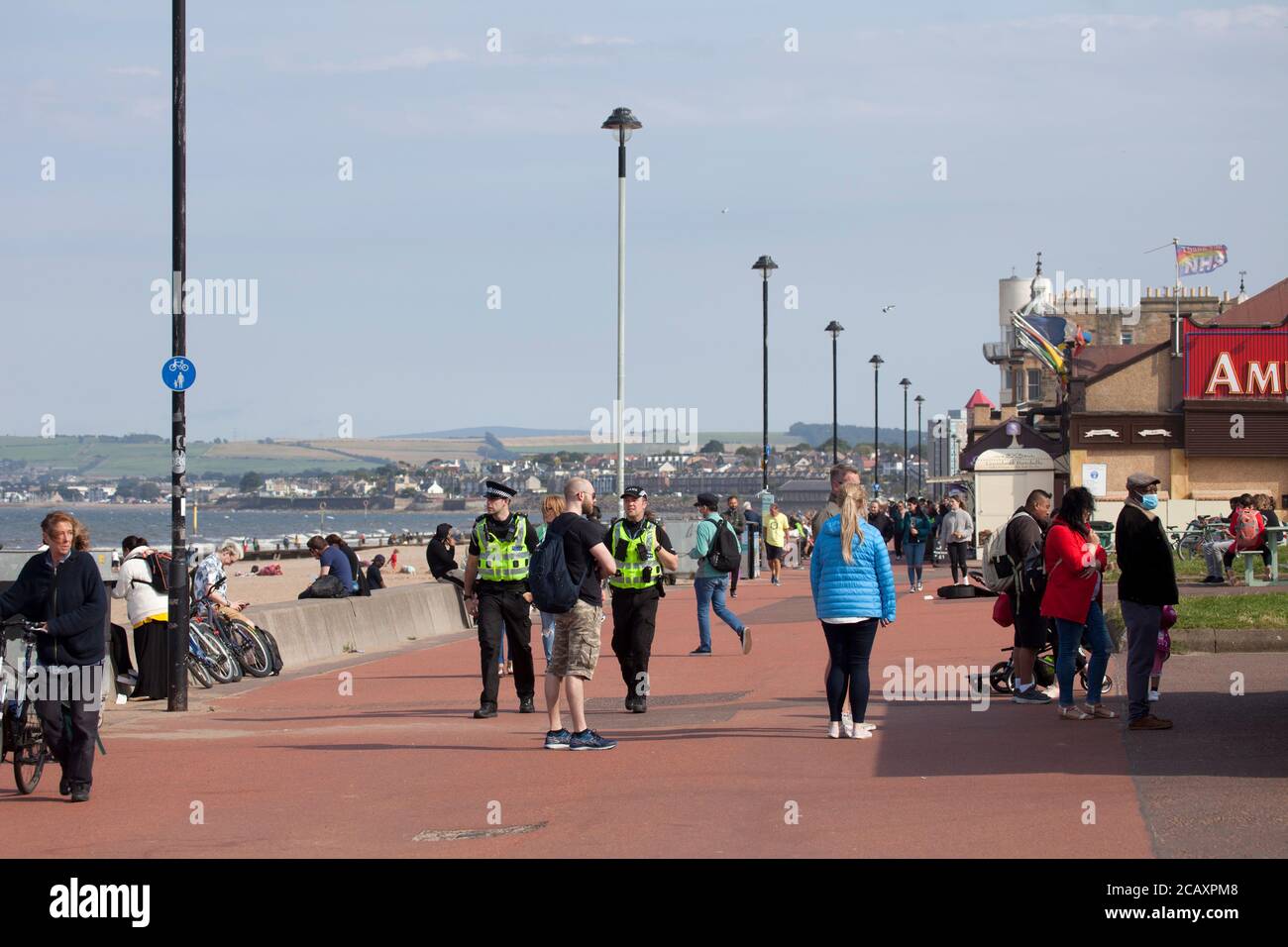 Portobello, Edimburgo, Scozia, Regno Unito. 9 agosto 2020. Più persone sulla spiaggia e sul lungomare nel tardo pomeriggio. Foto Stock