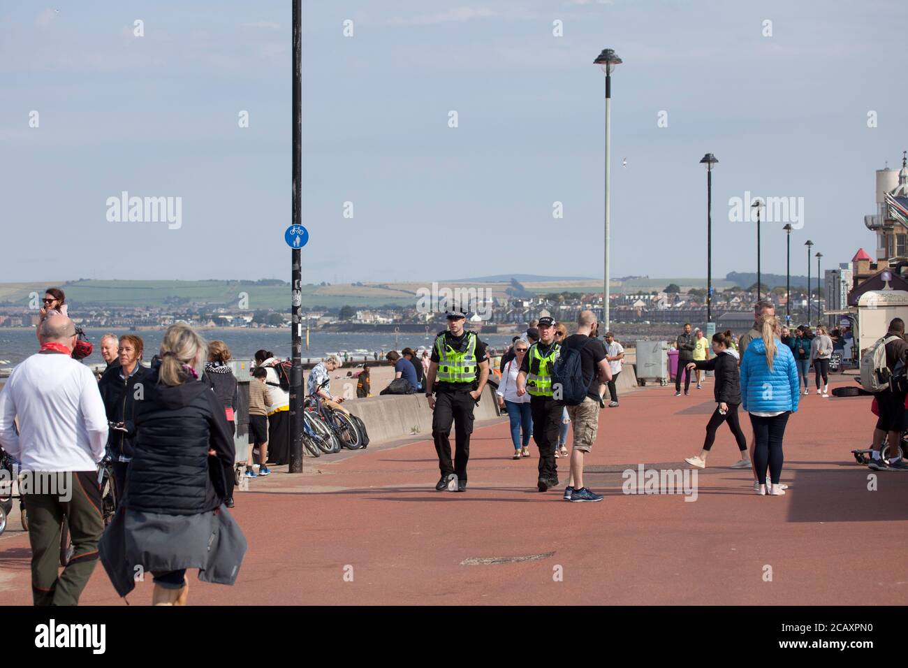 Portobello, Edimburgo, Scozia, Regno Unito. 9 agosto 2020. Due ufficiali di polizia in pattuglia, ma senza alcuna attività per riguardarli. Più persone sulla spiaggia e sul lungomare nel tardo pomeriggio. Foto Stock