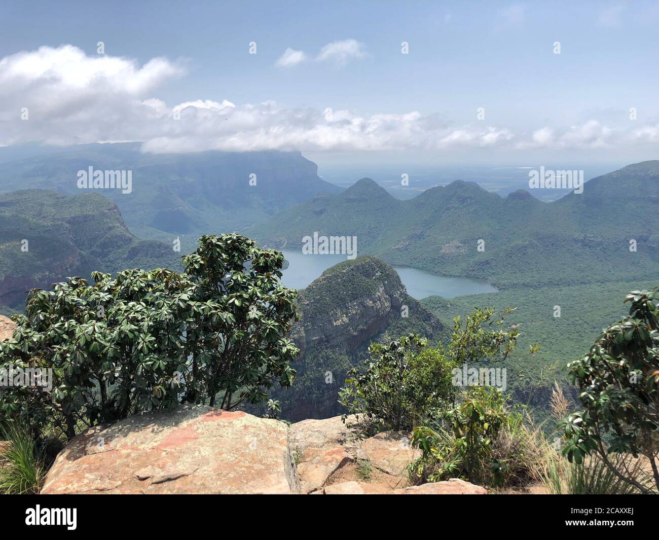 Vista lontana da un altopiano sopra il Blyde Canyon, Sudafrica in una giornata di nebbia e sole. Ore del mattino. Foto Stock