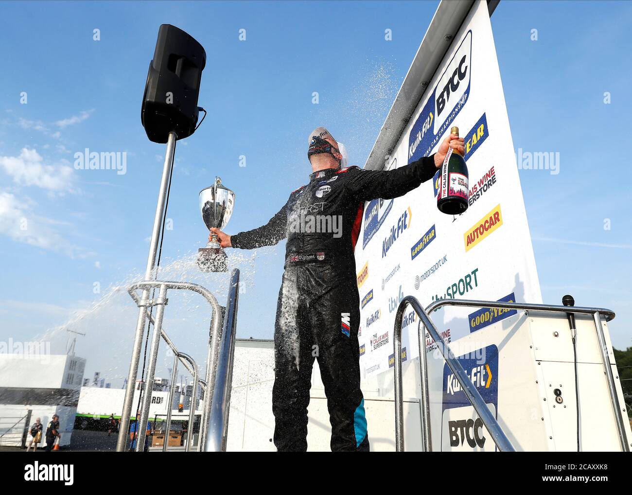 West Kingsdown, Kent, Regno Unito. 09 agosto 2020. Kwik Fit British Touring Car Championship, Race Day; Tom Olivant del Team BMW si diffonde con champagne dal podio con il trofeo vincitore del 1° posto dopo aver vinto gara 3 round 6 indossando una maschera credito: Action Plus Sports Images/Alamy Live News Foto Stock