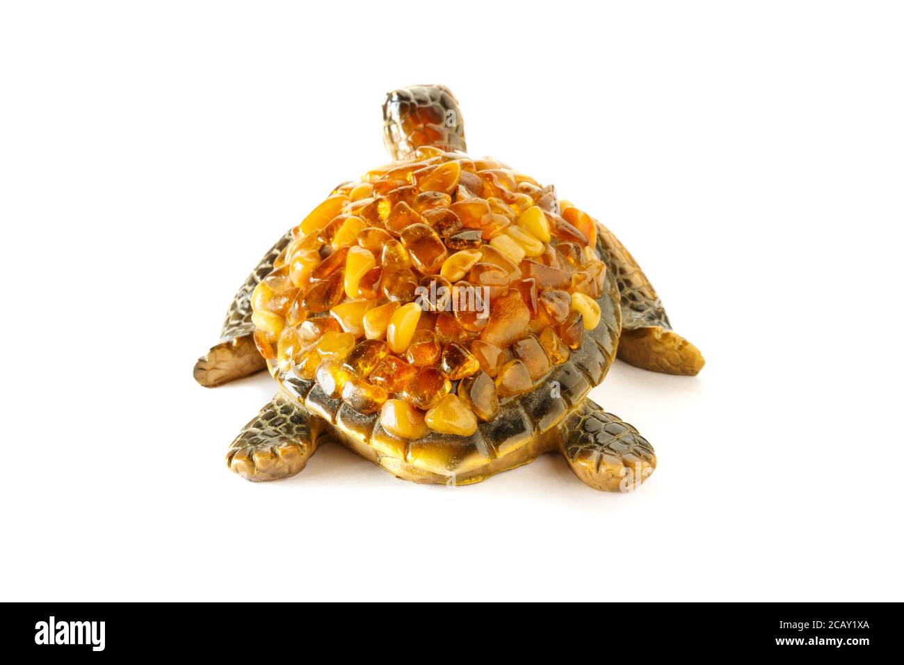 Figura di una tartaruga su sfondo bianco con pietre ambra sulla conchiglia. Vista posteriore. Foto Stock