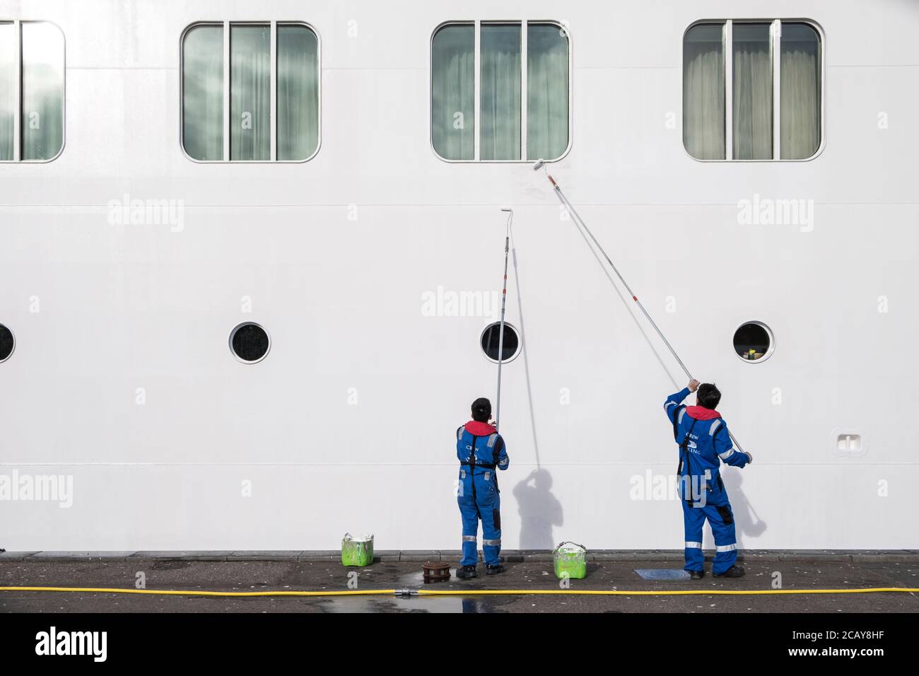 Due uomini che dipingono una nave da crociera enorme, Aalborg, Danimarca, Foto Stock