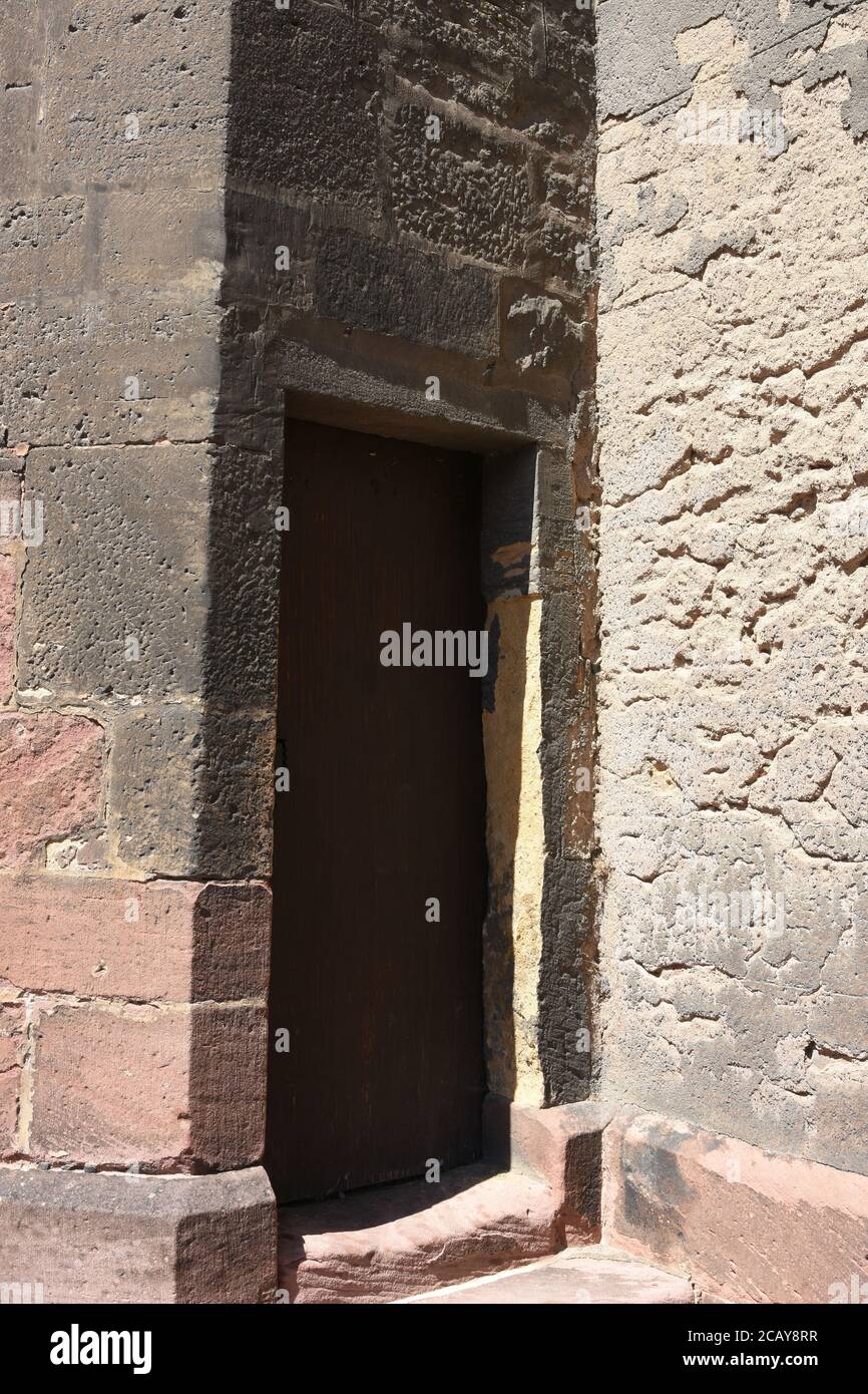 Vecchia piazza pesante, legno, massiccia porta in pietra muro per entrare Chiesa di San Martino in stile gotico nella città francese Colmar. Foto Stock