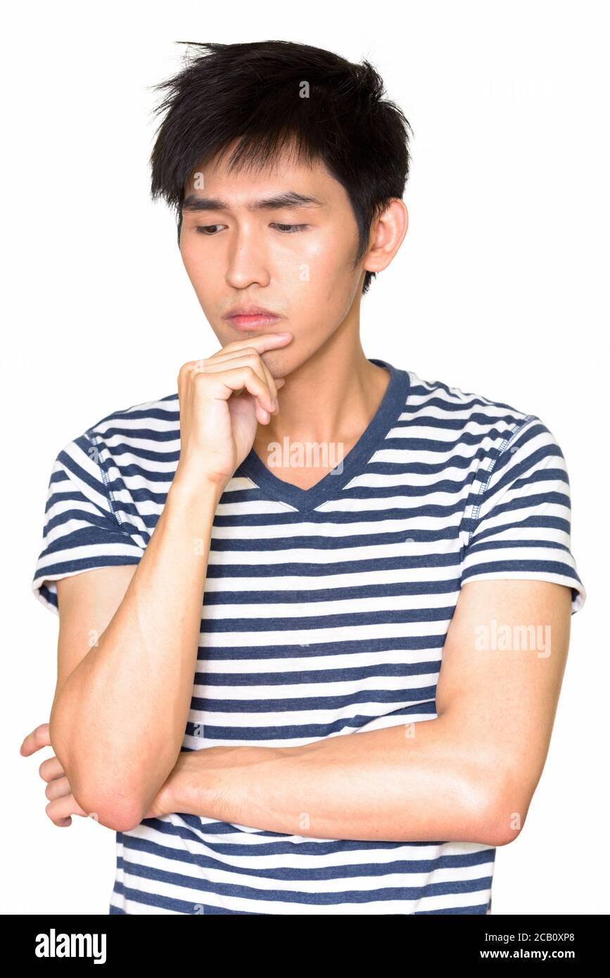 Studio di un uomo asiatico serio che pensa isolato contro il bianco sfondo Foto Stock