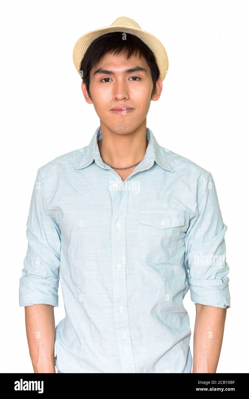 Studio shot di giovane bell'uomo asiatico che indossa cappello isolato su sfondo bianco Foto Stock