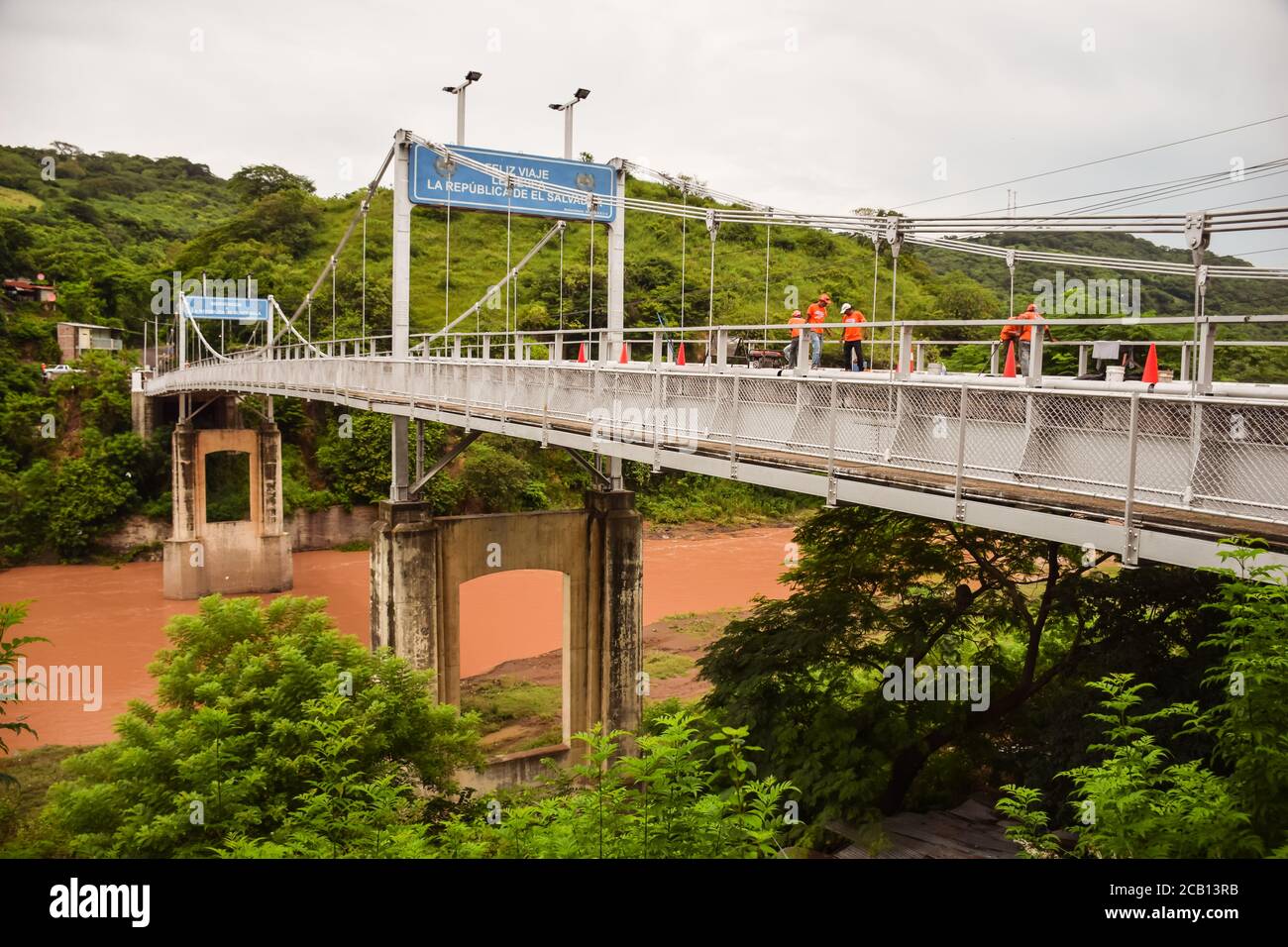 El Salvador - 30 ottobre 2017: ponte sulle acque marroni fiume che forma il confine tra El Salvador e Guatemala Foto Stock