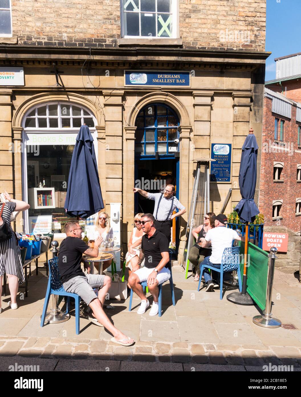 Persone sedute a bere fuori dal più piccolo bar di Durham City su Elvet Bridge, Durham City, Inghilterra, Regno Unito Foto Stock