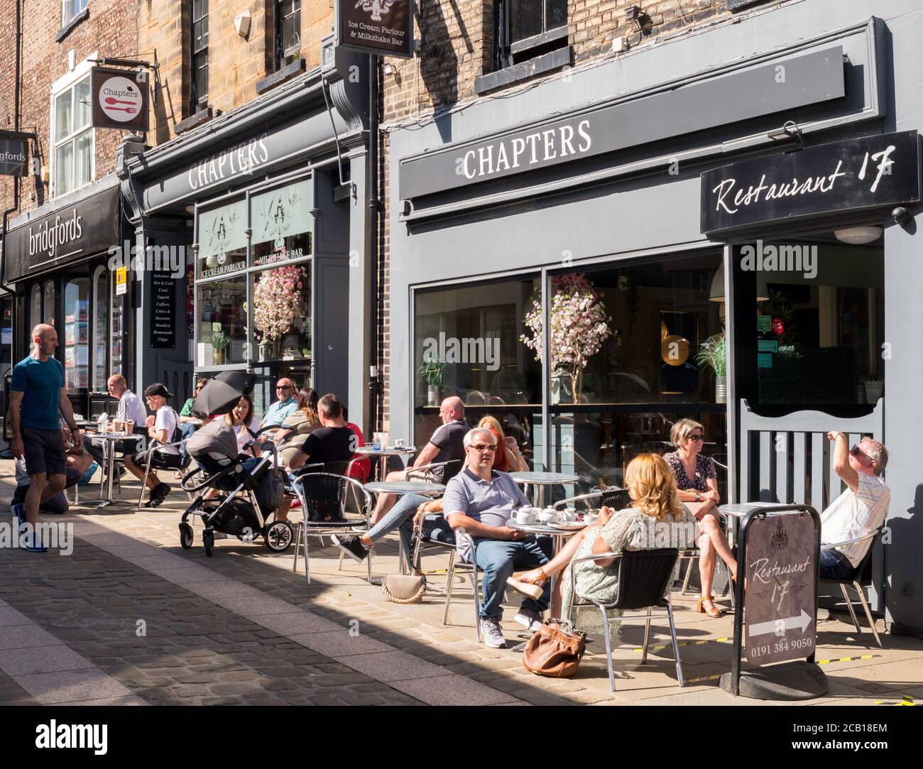Persone che siedono fuori Chapters sala da tè e ristorante nella città di Durham, Inghilterra, Regno Unito Foto Stock