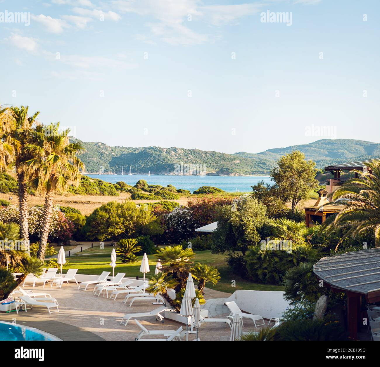 Paesaggio mediterraneo. Lettini con ombrelloni. Lussuosa vista panoramica sul Mar Mediterraneo. Sardegna. Italia. Foto Stock