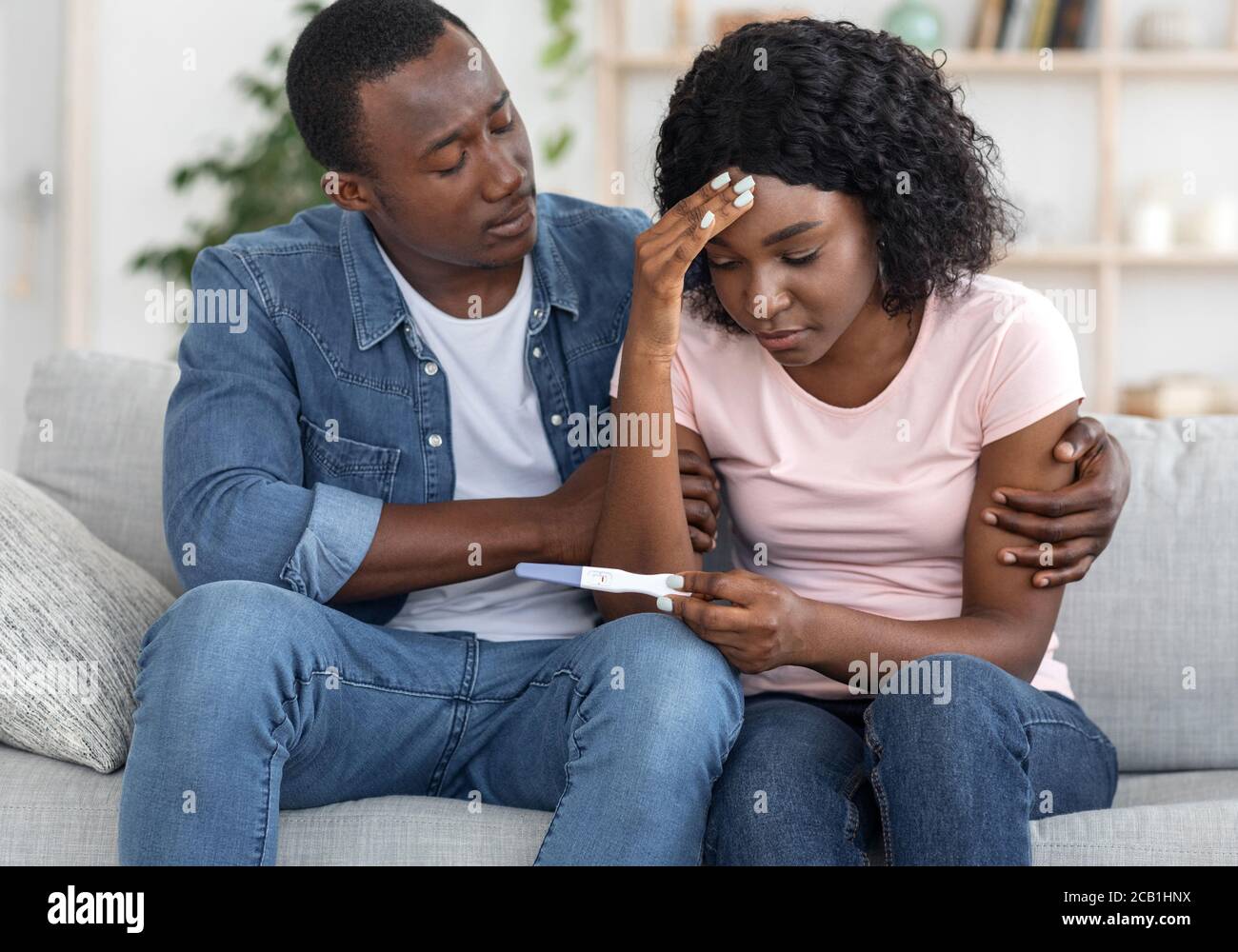 Closeup di nero sconvolto couple con test di gravidanza negativo Foto Stock